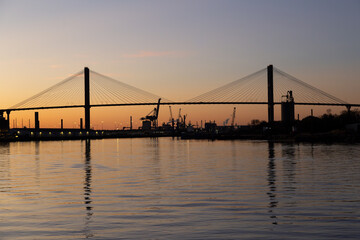 The 1991 cable-stayed Talmadge Memorial Bridge over the Savannah River seen in silhouette during a golden hour sunset