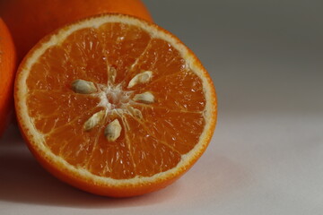 close up photo slice orange, orange slice put on flor and inside has seed of orange, haft orange...