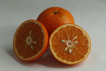 close up photo slice orange, orange slice put on flor and inside has seed of orange, haft orange slice put on floor