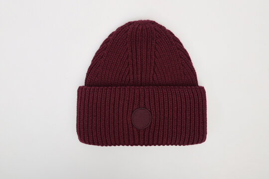 Burgundy men's knitted classic hat isolated on white background. Winter wool beanie hat, headwear. Templates, mock up, Men's cap for winter. Flat lay