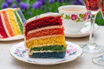 Multi layered rainbow cake set on garden table - outdoor dining