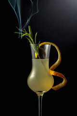Limoncello garnished with a steaming rosemary branch.