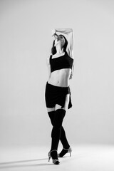 Passionate latina dancer in the studio is dancing in small black dress