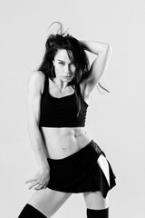 Passionate latina dancer in the studio is dancing in small black dress