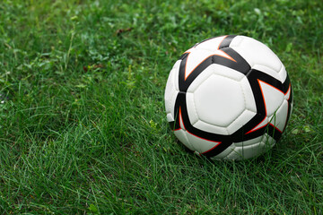 Fototapeta na wymiar New soccer ball on fresh green grass outdoors, space for text