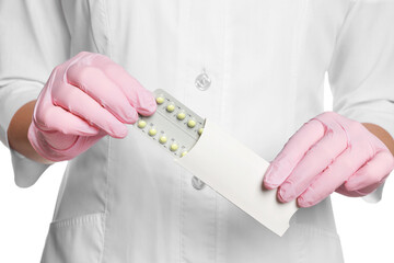 Doctor holding blister of oral contraception pills on white background, closeup