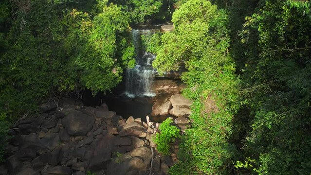Group exploring in dense jungle waterfall. Breathtaking aerial view flight drone