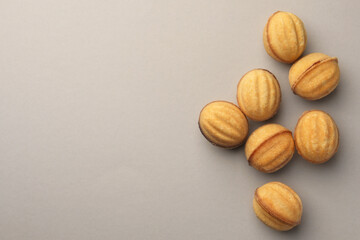 Homemade walnut shaped cookies with condensed milk on light grey background, flat lay. Space for text
