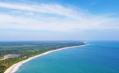 Fototapeta na wymiar Aerial view of the tropical ocean landscape with a beach. Beautiful southern sea wallpaper for tourism and advertising. Asian landscape, drone photo