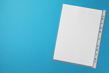 Punched pocket with paper sheet on light blue background, top view. Space for text