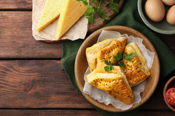 Fresh delicious puff pastry and ingredients on wooden table, flat lay. Space for text