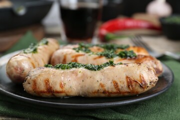 Tasty fresh grilled sausages with sauce on table, closeup
