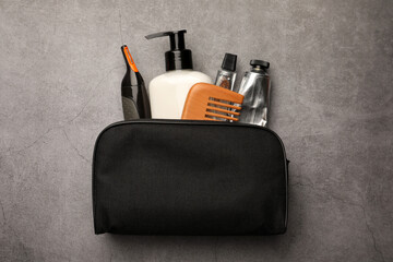 Preparation for spa. Compact toiletry bag with different cosmetic products on grey textured...