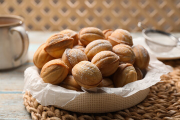 Bowl of delicious nut shaped cookies on grey wooden table, closeup