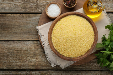 Raw couscous and ingredients on wooden table, flat lay. Space for text