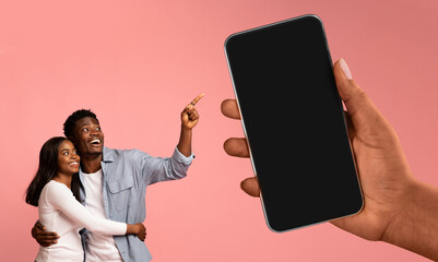 Romantic Black Couple Pointing At Huge Smartphone In Female Hand