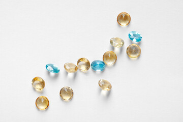 Different beautiful gemstones for jewelry on white background, flat lay