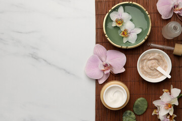 Composition with different spa products and flowers on white marble table, top view. Space for text