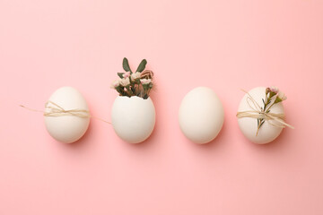 Chicken eggs and natural decor on pink background, flat lay. Happy Easter
