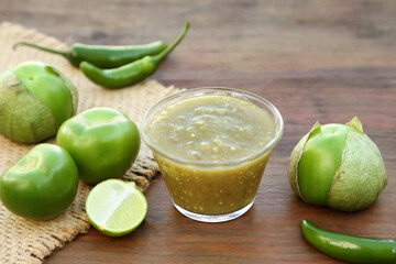 Tasty salsa sauce and ingredients on wooden table, closeup