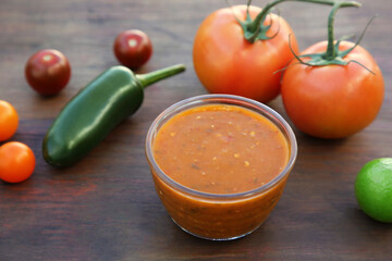 Tasty salsa sauce and ingredients on wooden table, closeup