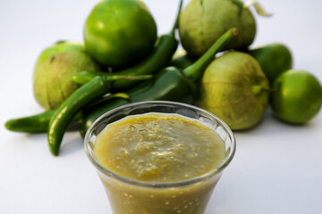 Bowl with delicious salsa sauce and ingredients on white background, closeup