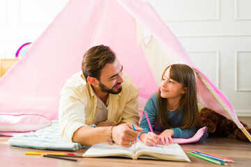 Happy father and daughter coloring a book together