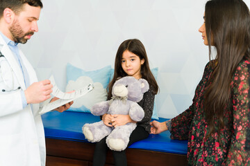 Sad young kid feeling sick at the pediatrician