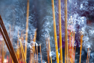 Many scented incense sticks burning in a Buddhist shrine, creating a fragrant and smoky atmosphere....