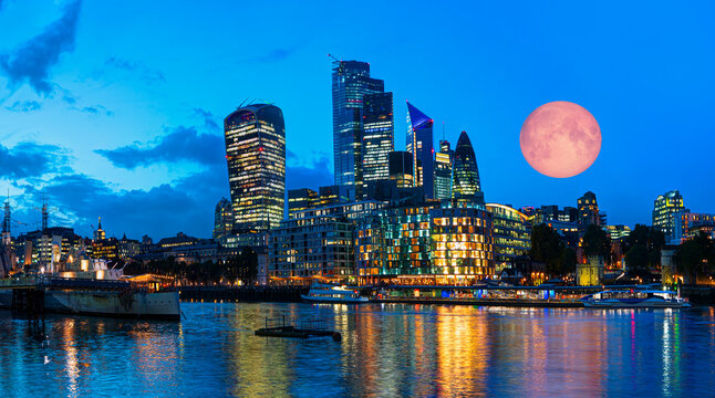Panorama of the modern skyline on Thames river at twilight blue hour with full moon - London, United Kingdom "Elements of this Image Furnished by NASA"