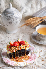 Dark beer cake garnished with cream cheese, strawberries, rosemary, nuts served with hot tea.