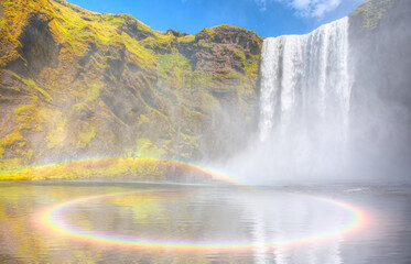 Icelandic Landscape concept - View of famous Skogafoss waterfall - Rounded amazing rainbow over the water