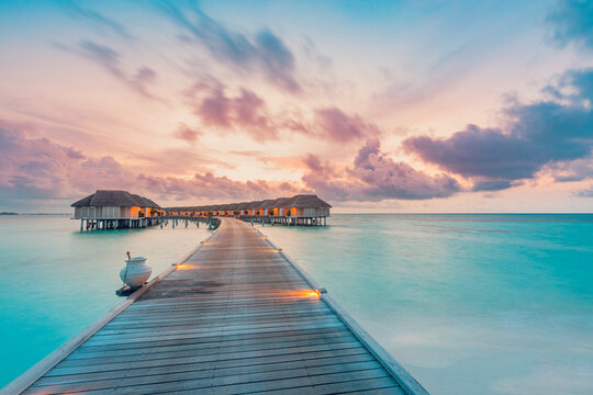 Amazing beach landscape. Beautiful Maldives sunset seascape view. Horizon colorful sea sky clouds, over water villa pier pathway. Tranquil island lagoon, tourism travel background. Exotic vacation
