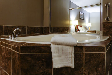 A hot water jacuzzi and towels in a hotel room.