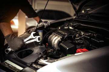 Car care maintenance and servicing, Close-up hand technician auto mechanic using the wrench to repairing change spare part car engine problem and car insurance service support. - obrazy, fototapety, plakaty