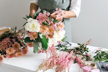 A flower boutique employee creates a flower arrangement.