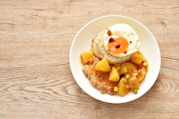 fried rice garlic and butter with pork steak dressing potato curry sauce topping egg on plate