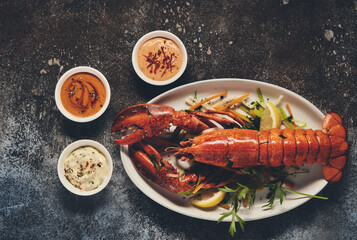 Tasty lobster with various sauces on table