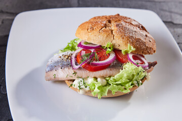 Appetizing burger with lettuce and fish on plate