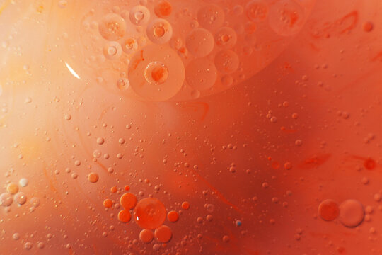 Gold and red Oil bubbles close up. circles of orange and pink water macro. abstract shiny background