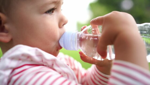Small child drinks water from a bottle with a drinking valve