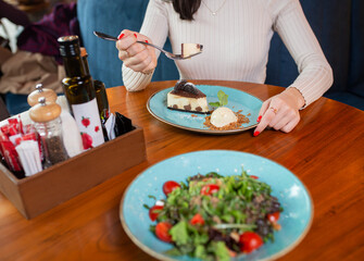 a girl without a face eats dessert in a cafe