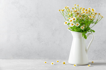 White chamomile flowers bouquet in vase on white background with copy space. Still life. Womens day