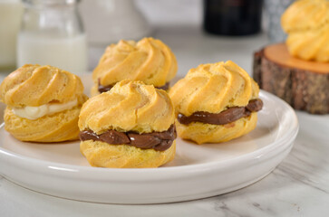 Homemade eclairs with chocolate or vanilla filling
