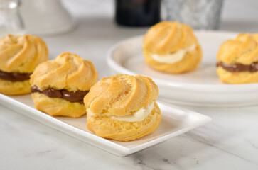 Homemade eclairs with chocolate or vanilla filling
