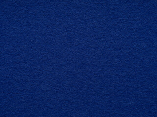 Dark blue matte felt fiber texture. Natural wool for text, lettering, patchworkor 3d art work. Full frame backdrop wallpaper. Matt retro velvet pattern or vintage background in high resolution.