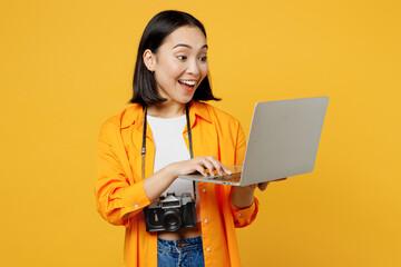 Young IT woman in summer casual clothes hold use work on laptop pc computer isolated on plain...