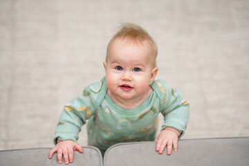Fototapeta premium Portrait of charming Caucasian baby toddler with blue eyes in home in children room