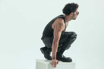 casual man squatting on the chair and looking away