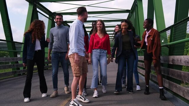 Large group of friends walking and having fun outdoors together on a bridge. Concept: Lifestyle, friends, diversity